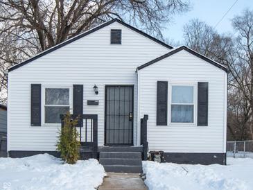 White house with black shutters, gray door, and snowy yard at 3501 Caroline Ave, Indianapolis, IN 46218