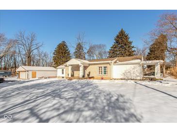 Brick ranch house with attached garage, situated on a snow-covered lot at 4202 W Mooresville Rd, Indianapolis, IN 46221