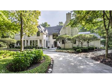 White brick home with a black roof and manicured landscaping at 11091 Crooked Stick Ln, Carmel, IN 46032