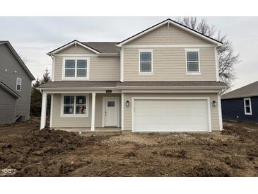 Two story home with white trim, a covered porch, two-car garage and tan siding at 5139 Cartland Dr, Indianapolis, IN 46239
