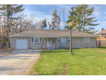 Charming single-story home featuring a stone facade, attached garage, and well-maintained front yard at 2010 N Irwin St, Indianapolis, IN 46219