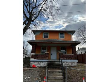 Two-story house with orange and blue siding, brick steps, and a small front yard at 2607 E 12Th St, Indianapolis, IN 46201