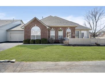 Charming brick home featuring arched windows, a well-manicured lawn, and inviting curb appeal at 2811 Grandview Ln, Greenwood, IN 46143