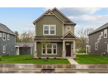 Two-story home showcasing an inviting covered front porch and a well-manicured lawn at 1717 Real St, Indianapolis, IN 46240