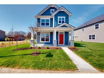 Charming two-story home boasting blue siding, white trim, a red front door, and a well-manicured lawn at 1721 Real St, Indianapolis, IN 46240