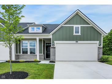 Charming exterior of a two-story home featuring green siding, a two-car garage, and a beautifully landscaped front yard at 9711 Palermo Ave, Indianapolis, IN 46239