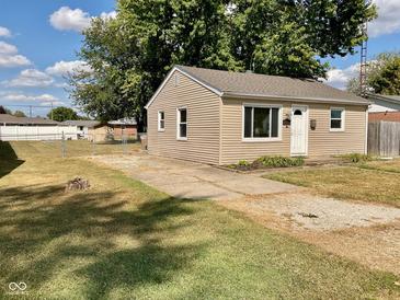 Tan house with a white door, small yard, and driveway at 2606 13Th St, Columbus, IN 47201