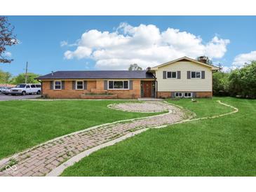 Inviting two-story home featuring a brick facade, manicured lawn, and charming brick walkway at 6327 E 52Nd Pl, Indianapolis, IN 46226
