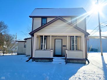 Two-story house with a snow covered front porch at 107 E Garfield St, Alexandria, IN 46001