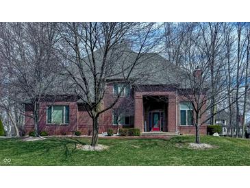 Charming brick home featuring a well-manicured lawn and mature trees at 13650 Golden Ridge Ln, Fishers, IN 46055