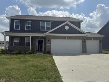 Two-story home boasts gray siding and a brick facade, complemented by a spacious, two-car garage at 251 Dyson Dr, Whiteland, IN 46184