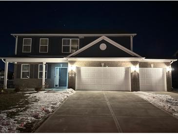 Two-story house with a gray exterior, white garage doors, and a concrete driveway at 251 Dyson Dr, Whiteland, IN 46184