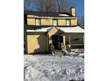 Cute yellow house with snow covered yard at 2615 Baltimore Ave, Indianapolis, IN 46218