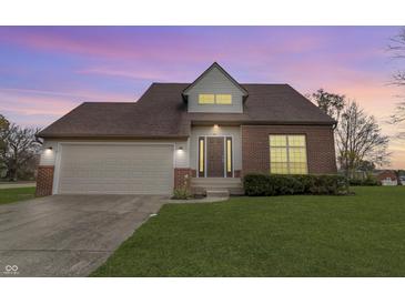 Brick house with attached garage, landscaping, and a well-maintained lawn at 297 Van Buren St, Greenfield, IN 46140