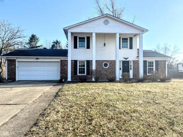 Traditional two-story home featuring a symmetrical facade, white siding, brick accents, and a two-car garage at 3015 Olive Branch Rd, Greenwood, IN 46143