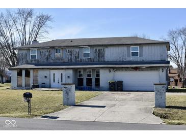 Two-story house needing repairs, featuring a large driveway and attached garage at 4349 Alhambra Dr, Anderson, IN 46013