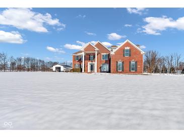 Brick house on a snowy lot with a detached garage at 4450 W 300 N, Fairland, IN 46126