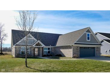 Brick ranch home with gray roof, attached garage, and landscaped lawn at 4667 W Meadows Ln, New Palestine, IN 46163