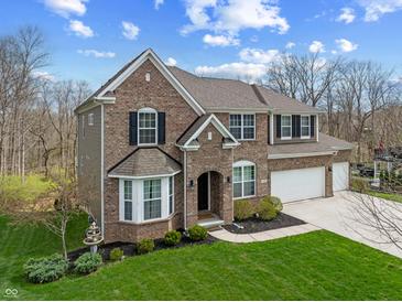 Attractive two-story brick home with an attached two-car garage and landscaped front yard at 6711 Colville Pl, Indianapolis, IN 46236