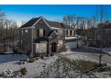 Two-story brick home with a spacious front yard and attached garage at 6711 Colville Pl, Indianapolis, IN 46236