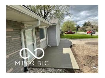 Cozy home exterior featuring a stone facade, covered porch, and landscaped front yard at 117 Tracy Rd, Whiteland, IN 46184