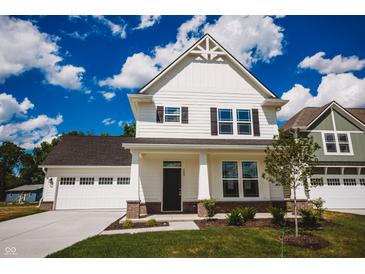 Charming two-story home with white siding, a well-manicured lawn, and an attached garage under a bright blue sky at 1841 Luther St, Indianapolis, IN 46203