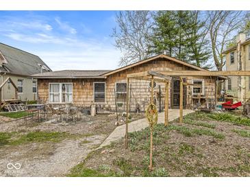 Charming single-story home with wood shingles, inviting front entrance, and an outdoor seating area at 2230 E 75Th St, Indianapolis, IN 46240