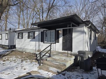 A charming home boasts a covered front porch and fresh white siding, promising cozy curb appeal at 3951 N Pasadena St, Indianapolis, IN 46226
