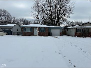 Brick ranch home with attached garage and snow-covered yard at 835 E Berwyn St, Indianapolis, IN 46203