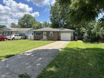 Charming single-story home with a brick facade, inviting front yard and a private driveway at 835 E Berwyn St, Indianapolis, IN 46203