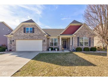 Charming brick home featuring a two-car garage, manicured lawn, and inviting front porch at 15759 Hargray Dr, Noblesville, IN 46062