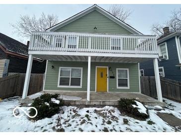 Charming two-story home with a yellow door and balcony at 334 Hamilton Ave, Indianapolis, IN 46201