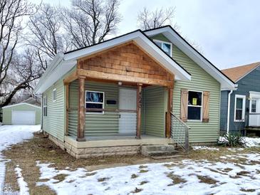 Updated light green house with a welcoming front porch at 4840 Hillside Ave, Indianapolis, IN 46205