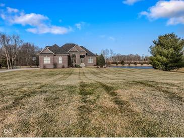 Brick house with large yard, attached garage, and pond view at 8152 Cottonwood Dr, Martinsville, IN 46151