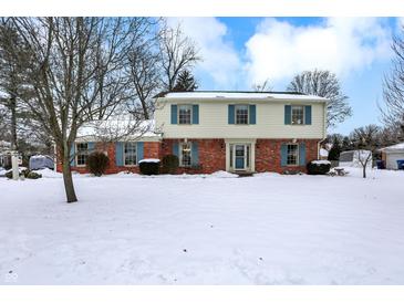 Brick two-story house with blue shutters, snowy front yard at 12104 Windsor Dr, Carmel, IN 46033