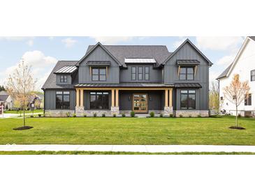 Gray farmhouse exterior with a stone base, light brown accents, and a manicured lawn at 14028 Grannan Ln, Carmel, IN 46074