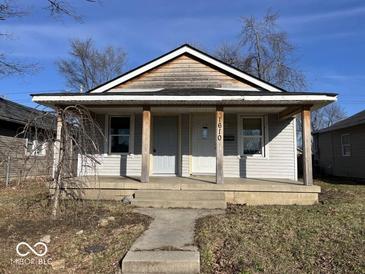 Modest bungalow with covered porch and two entry doors under a simple gable roof, offering potential for dual occupancy at 1610 Hoefgen St, Indianapolis, IN 46203