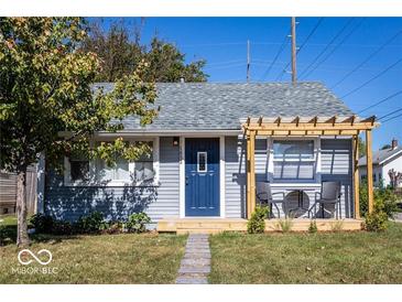 Charming bungalow with gray siding, blue door, and pergola-covered deck at 1654 Iowa St, Indianapolis, IN 46203