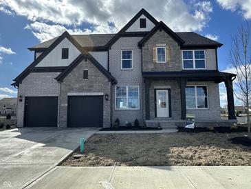 Two-story home with gray brick, black trim, gabled roof, covered entry, and two-car garage at 19962 Stone Side Ct, Westfield, IN 46074