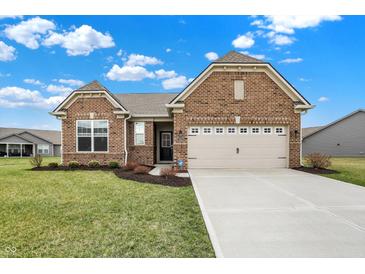 Charming brick home featuring an attached two-car garage and well-manicured front lawn, set against a sunny sky at 3844 Albert Ln, Bargersville, IN 46106