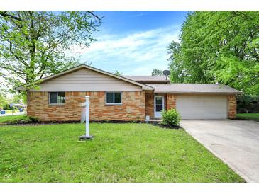 Charming brick home featuring a well-maintained lawn and attached two-car garage at 9157 Neptune Dr, Indianapolis, IN 46229
