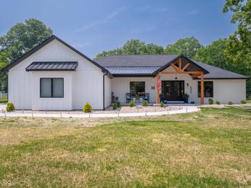 Stunning modern farmhouse with white siding, black accents, and a welcoming front porch at 958 J Mccool Way, Greenwood, IN 46142