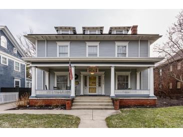 Charming multi-story home featuring a welcoming front porch with classic white columns and dormer windows at 1319 N New Jersey St, Indianapolis, IN 46202