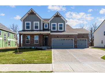 Charming two-story home featuring a brick and gray exterior with a well-manicured lawn and a spacious three-car garage at 5511 Sienna Ct, Brownsburg, IN 46112