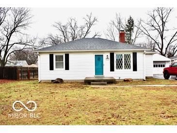 Cute ranch home with teal door, landscaping, and detached garage at 120 Hoss Rd, Indianapolis, IN 46217