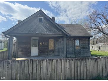 A rustic wood house with boarded windows, needing repairs at 1520 N Bancroft St, Indianapolis, IN 46201