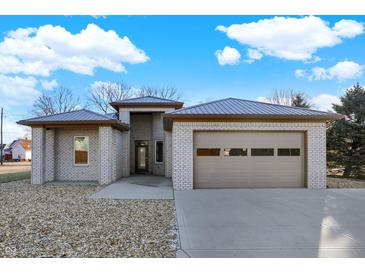 Charming single-story home with a gray brick exterior, attached garage, and well-maintained landscaping at 201 S Mckinley St, North Salem, IN 46165