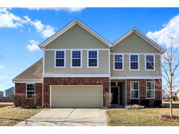 Charming two-story home features a two-car garage, brick accents, and a well-manicured lawn at 6115 Adler Ct, Whitestown, IN 46075