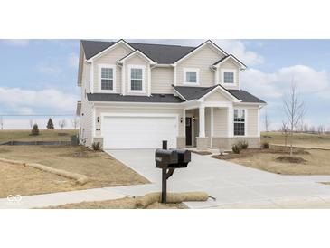 Charming two-story home with a two-car garage, well-manicured lawn, and inviting front porch at 6957 Hornbeam Cir, Brownsburg, IN 46112