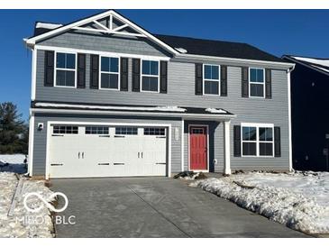 Two-story gray house with white garage doors and red front door at 7208 E Rising Sun N Cir, Camby, IN 46113